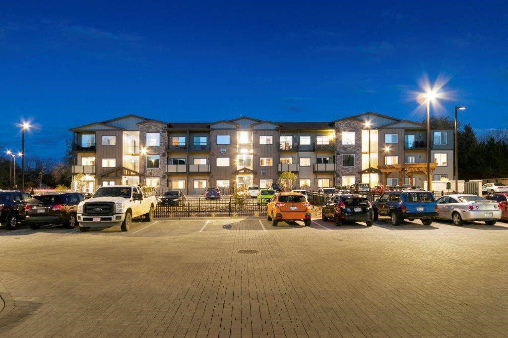 a parking lot in front of an apartment building at night