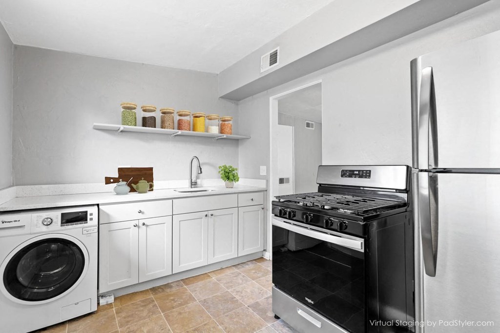 a kitchen with stainless steel appliances and white cabinets