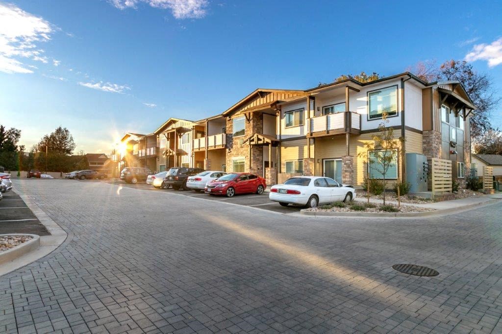a row of houses with cars parked in front of them