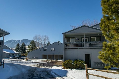 A house with a snow-covered ground in front of it.