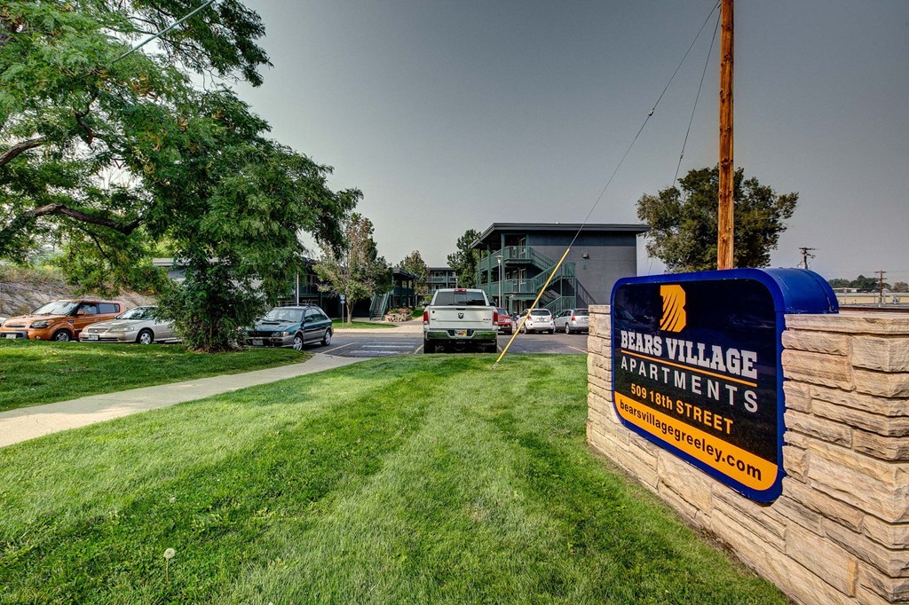 a sign for the east village apartments on the side of the street