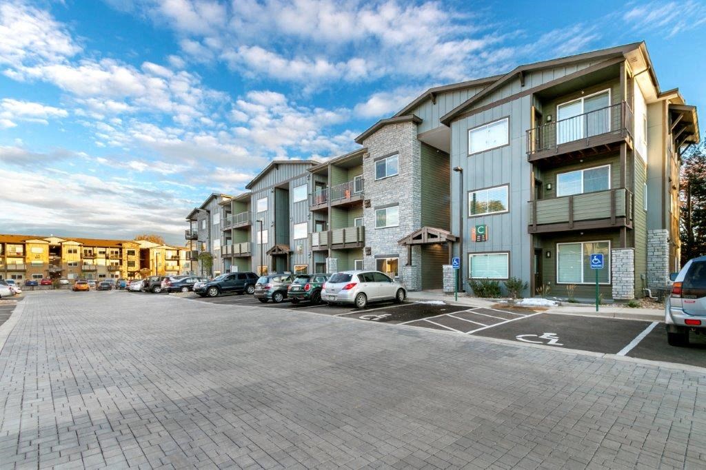 an empty parking lot in front of an apartment building