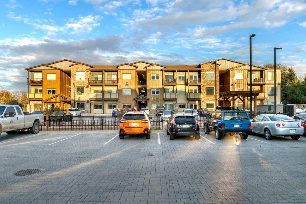 a parking lot with cars in front of an apartment building