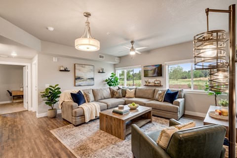A well-lit living room with a large couch, a coffee table, and a floor lamp.