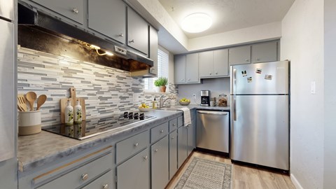 A kitchen with a stove top oven and a refrigerator.