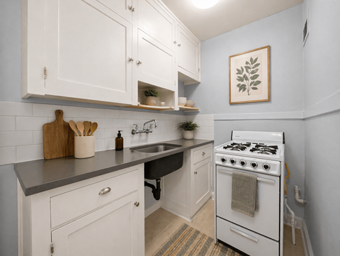 A kitchen with white cabinets and a white stove.