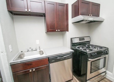 A kitchen with a black stove and a white sink.