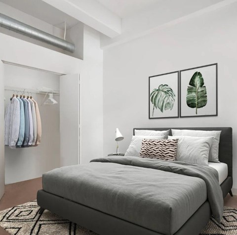 A bedroom with a large bed and two framed leaves on the wall.