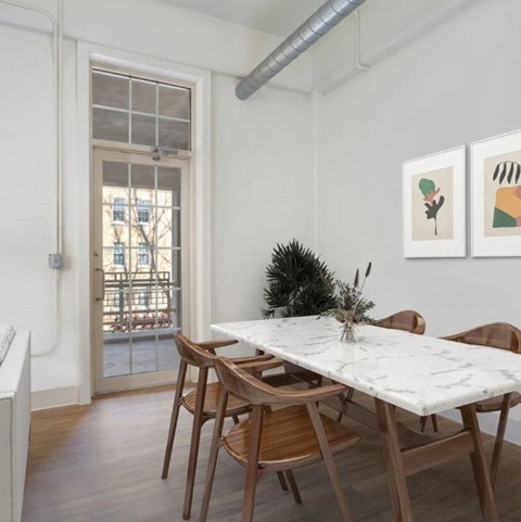 A dining room with a marble table and wooden chairs.
