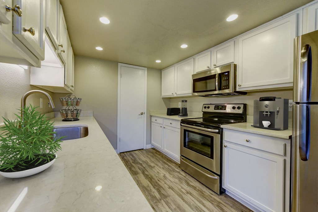 a kitchen with white cabinets and stainless steel appliances