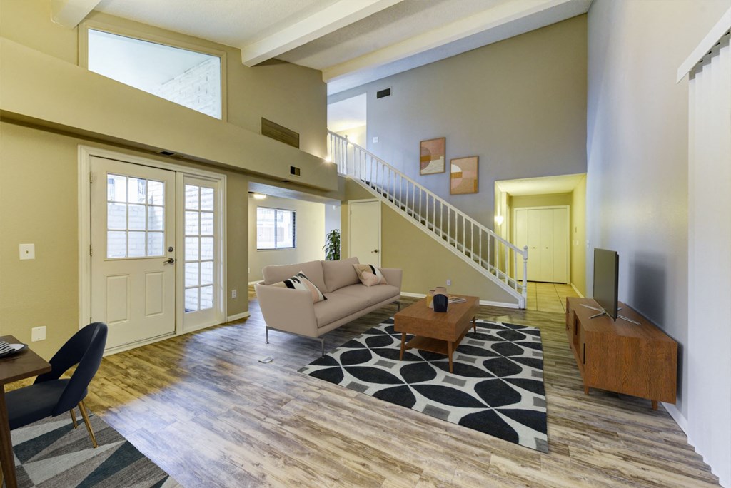 a living room with a couch and a table and a staircase