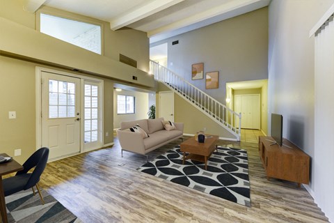 a living room with a couch and a table and a staircase
