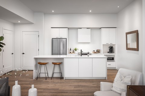 A modern kitchen with white cabinets and a bar area.