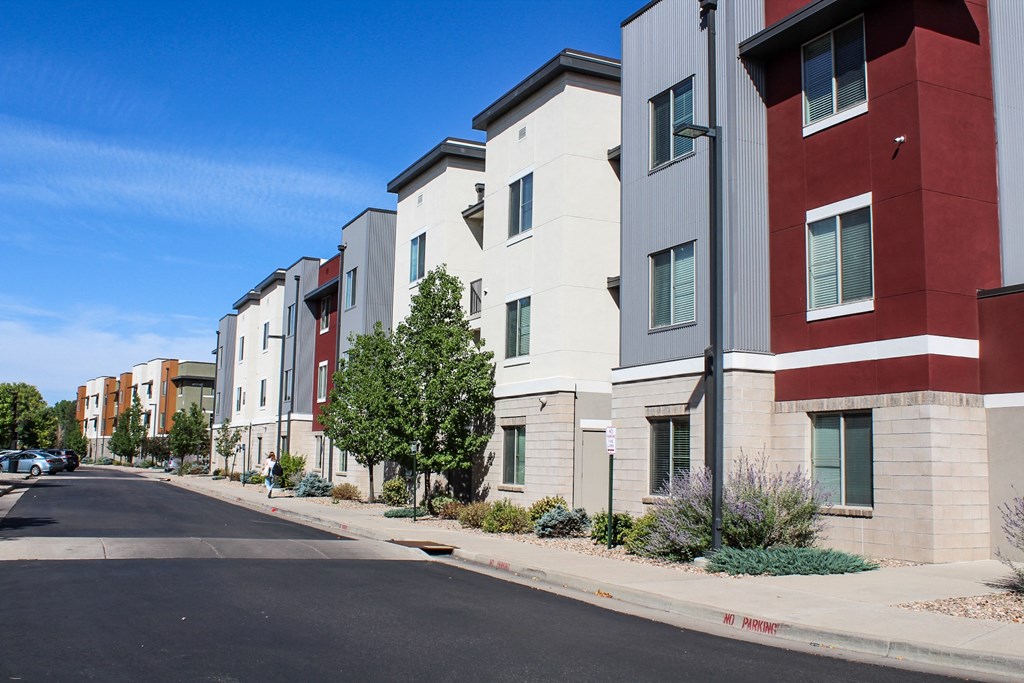 a row of apartment buildings on the side of a street