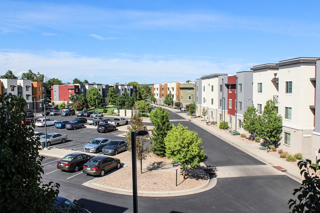 an aerial view of an empty parking lot with rows of apartment buildings
