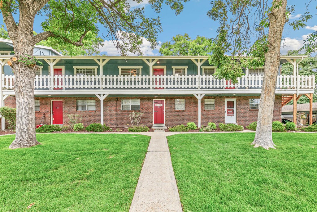 A red brick building with white trim and a green roof.