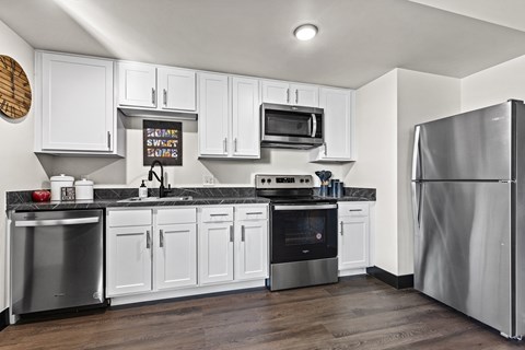 A modern kitchen with white cabinets and stainless steel appliances.