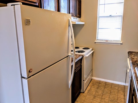a kitchen with a refrigerator and a stove and a window