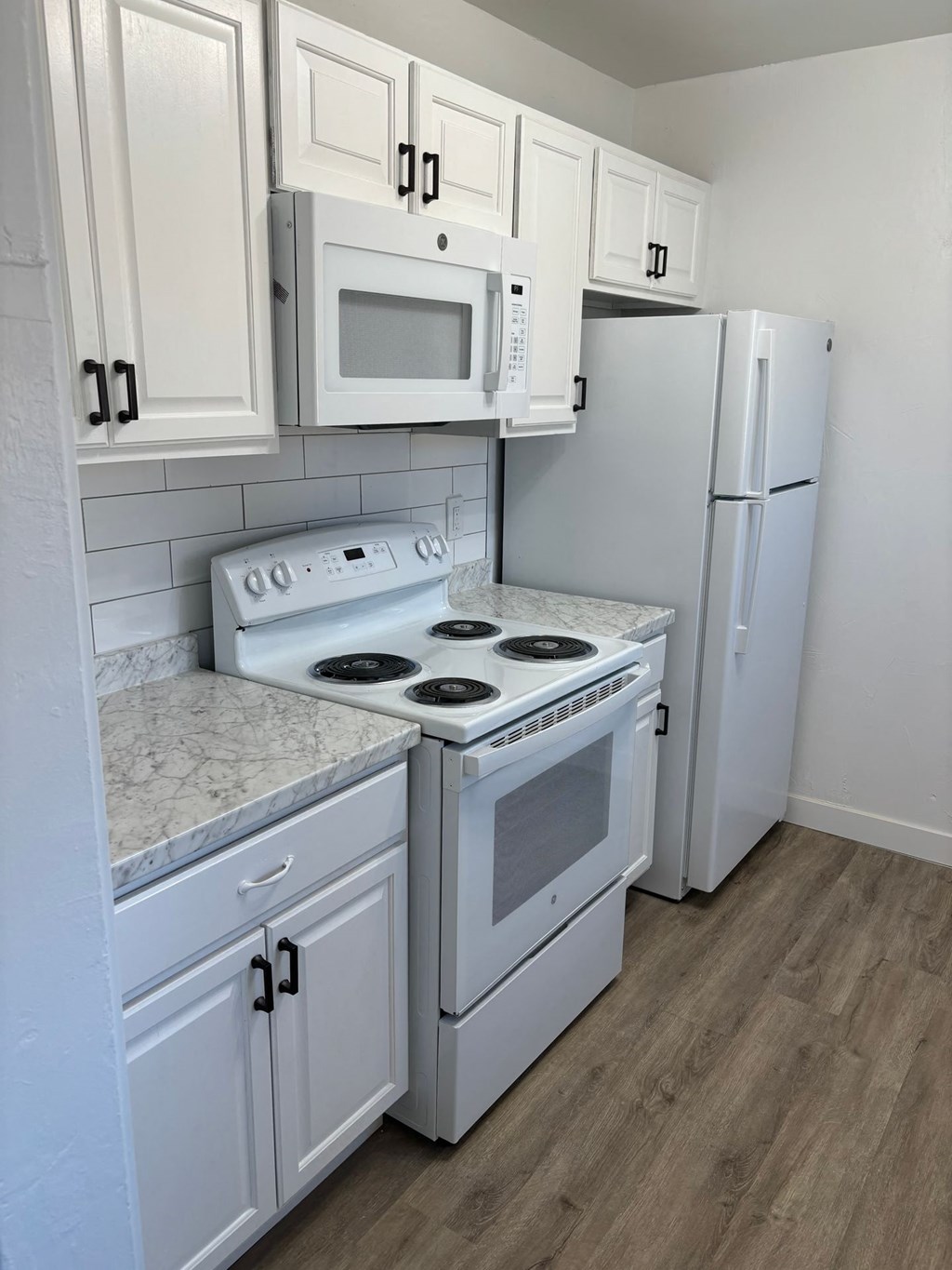 a kitchen with white appliances and white cabinets