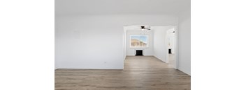 an empty room with white walls and a ceiling fan