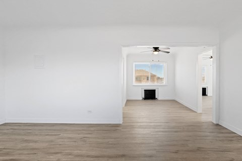 an empty room with white walls and a ceiling fan