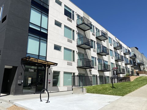 A modern apartment building with balconies and a clear blue sky.