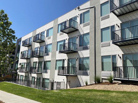A modern apartment building with balconies and a clear blue sky.