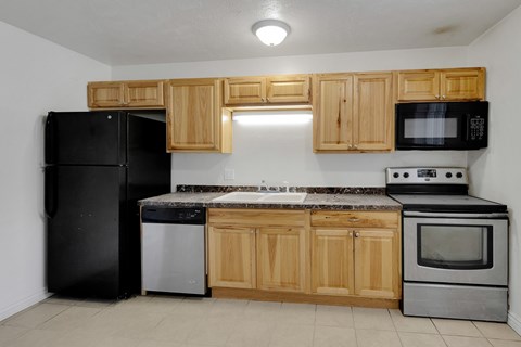 A kitchen with black appliances and wooden cabinets.
