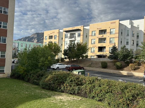 A car is parked on the side of a road in front of a building.