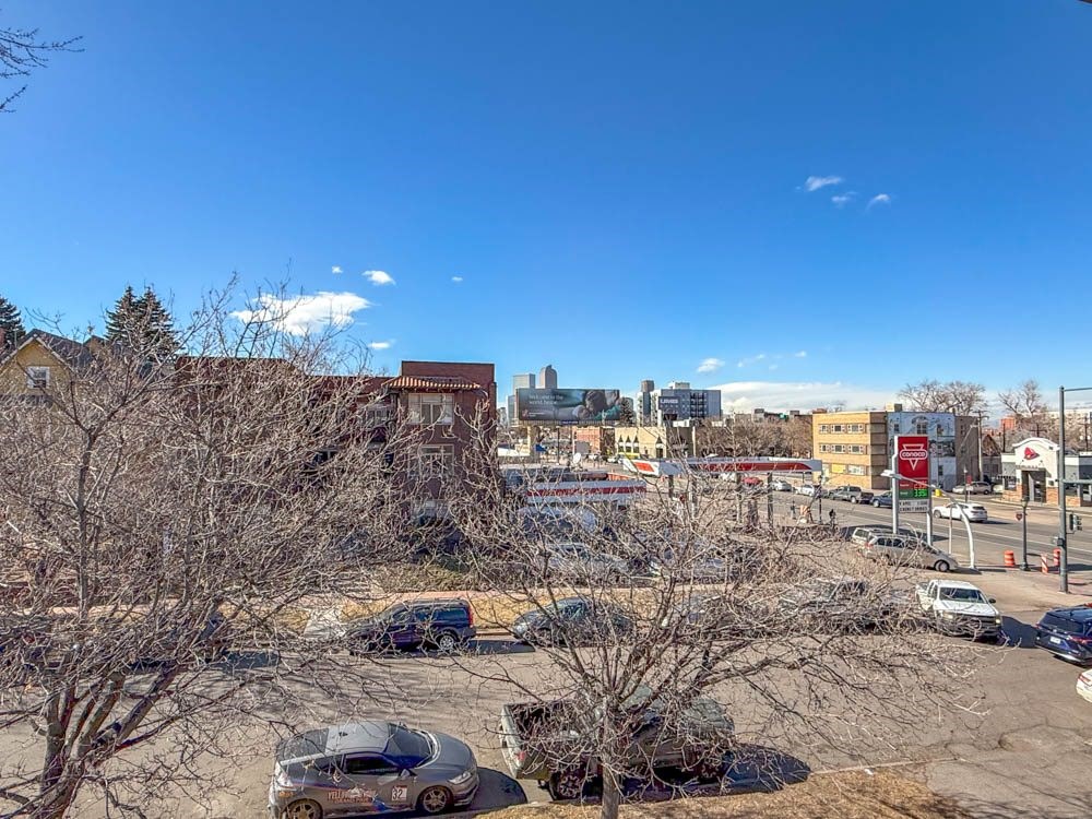 A parking lot with cars and a building in the background.
