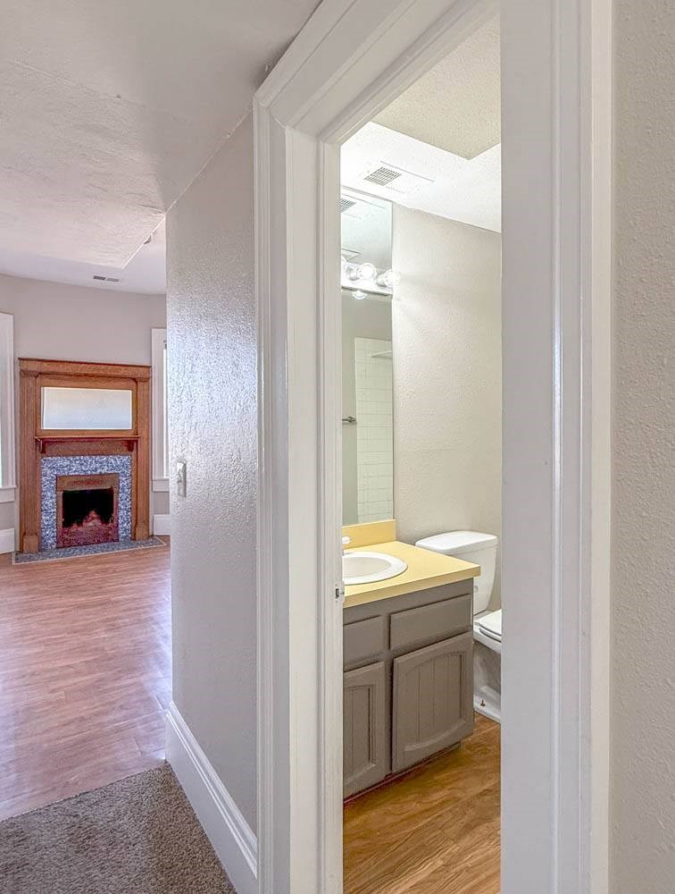 A bathroom with a toilet, sink and mirror.