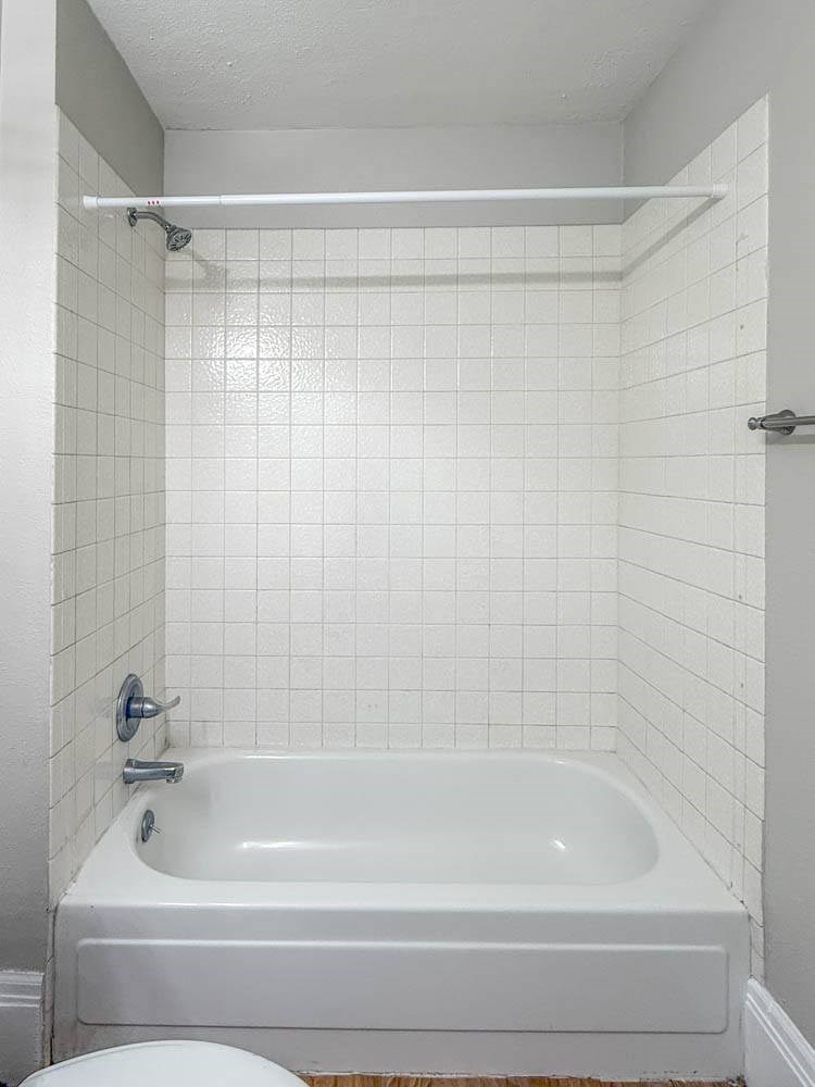 A white bathroom with a white tub and toilet.