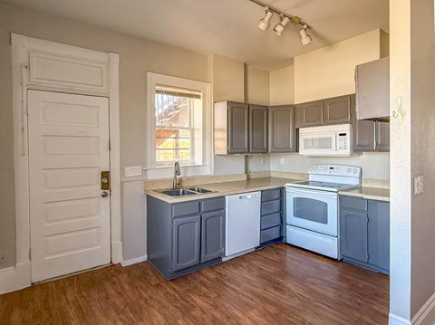 A kitchen with a white door and a window.