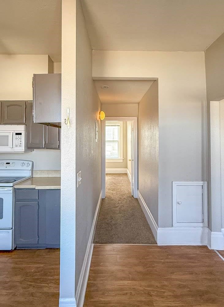 A long hallway with a washer and dryer in the kitchen area.