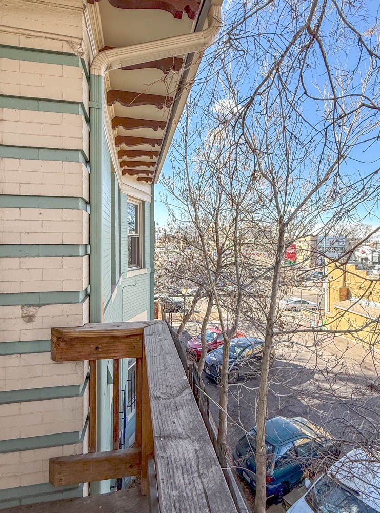A view from a balcony overlooking a parking lot.
