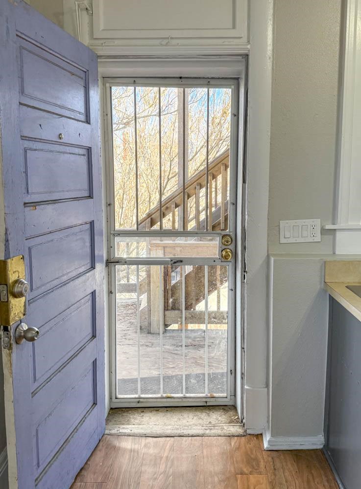 A blue door with a gold handle is open to a balcony.