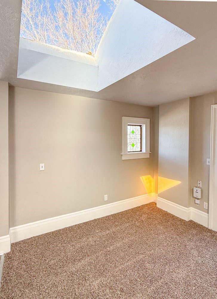 A room with a skylight and a small window.