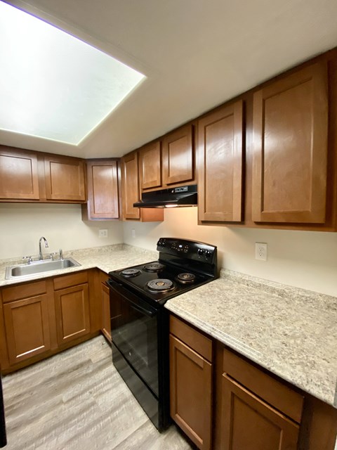 A kitchen with wooden cabinets and a black stove top oven.