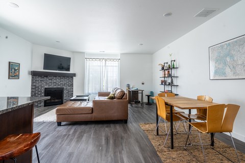 A living room with a couch, a chair, a table and a fireplace.
