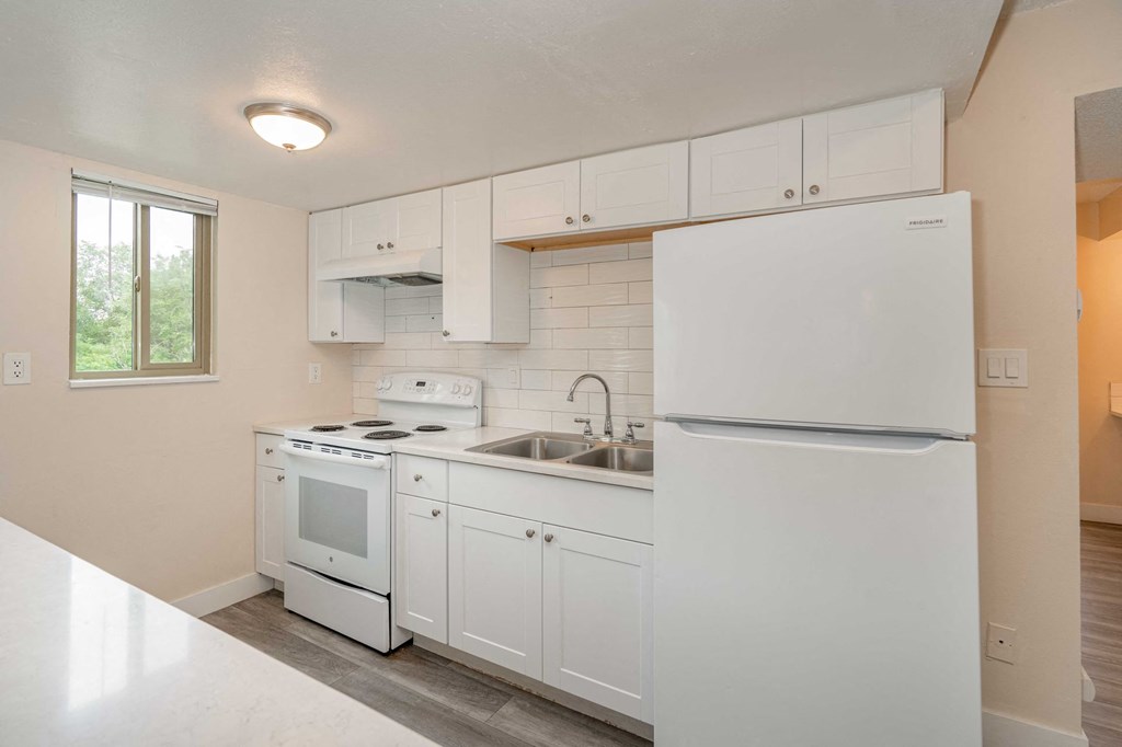 a kitchen with white cabinets and a stove and a sink