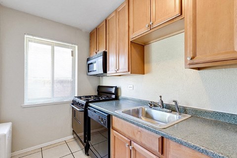 A kitchen with a black stove and a black microwave.