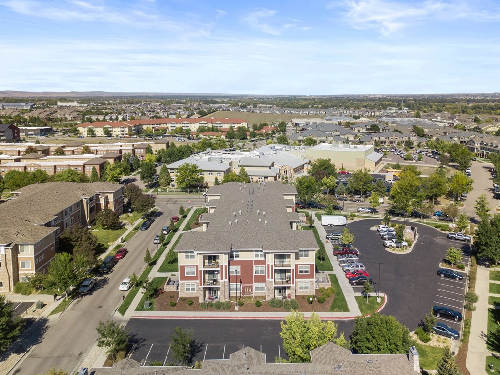 an aerial view of an apartment complex and parking lot
