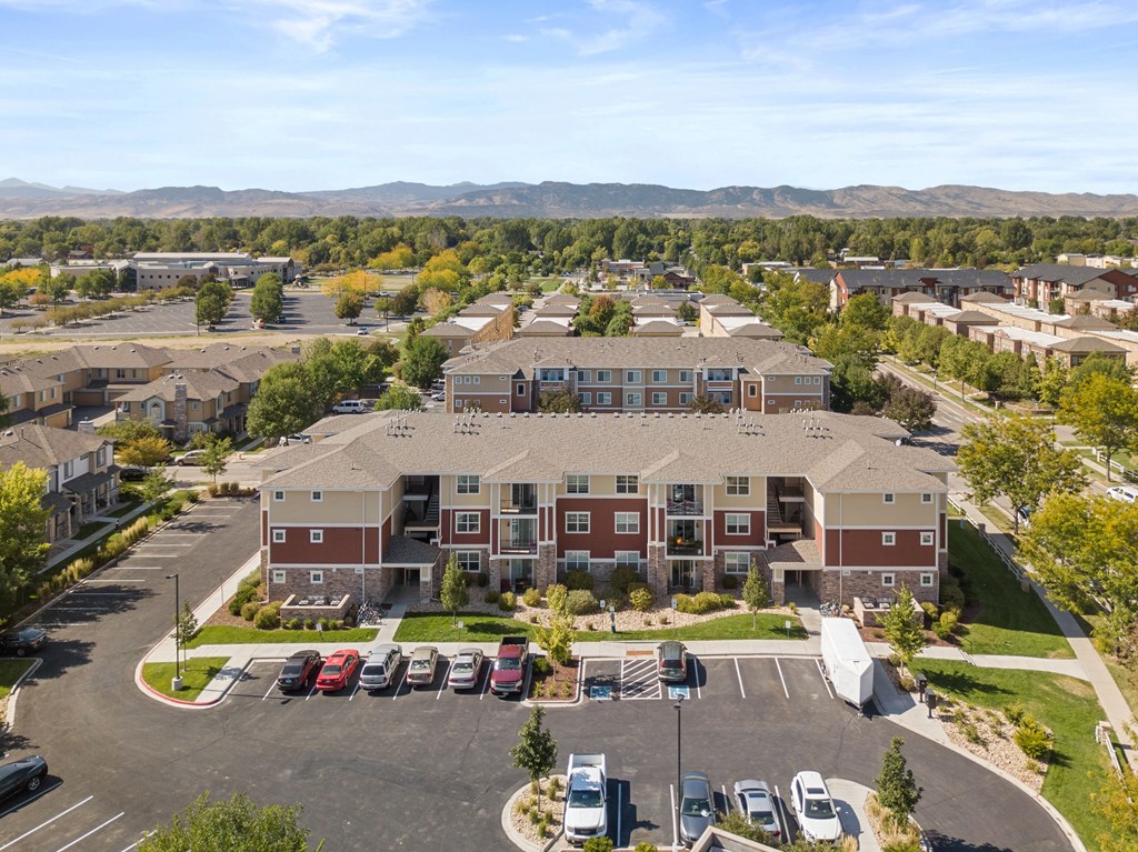 an aerial view of an apartment complex with cars parked in a parking lot