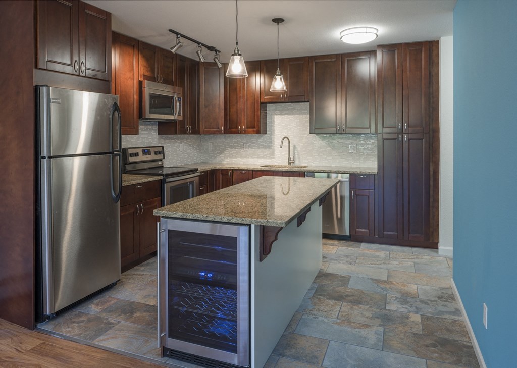 a kitchen with stainless steel appliances and a marble counter top