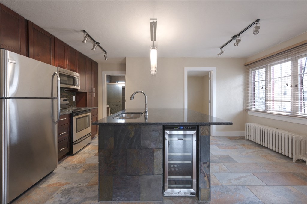 a kitchen with stainless steel appliances and a marble counter top