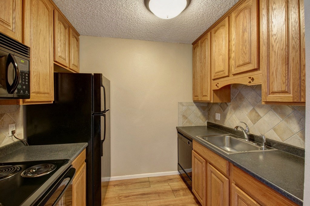 a kitchen with black appliances and wood cabinets