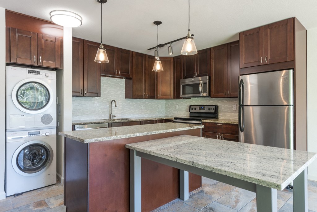 a kitchen with stainless steel appliances and a marble counter top
