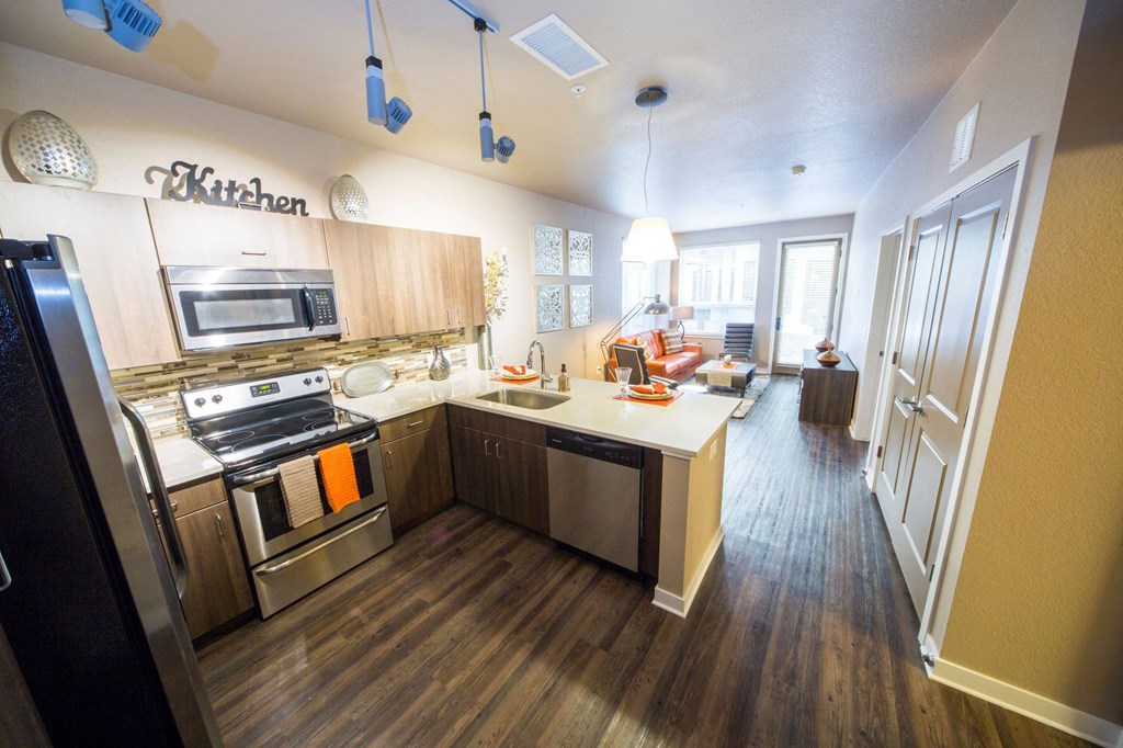a kitchen with wooden floors and stainless steel appliances