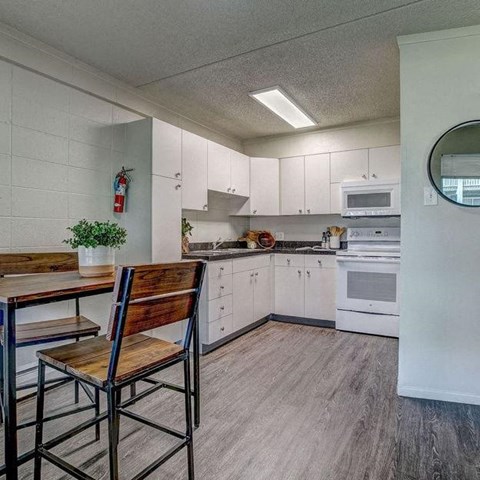 a kitchen with white cabinets and a table and chairs