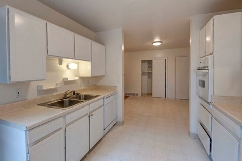 A kitchen with white cabinets and appliances.
